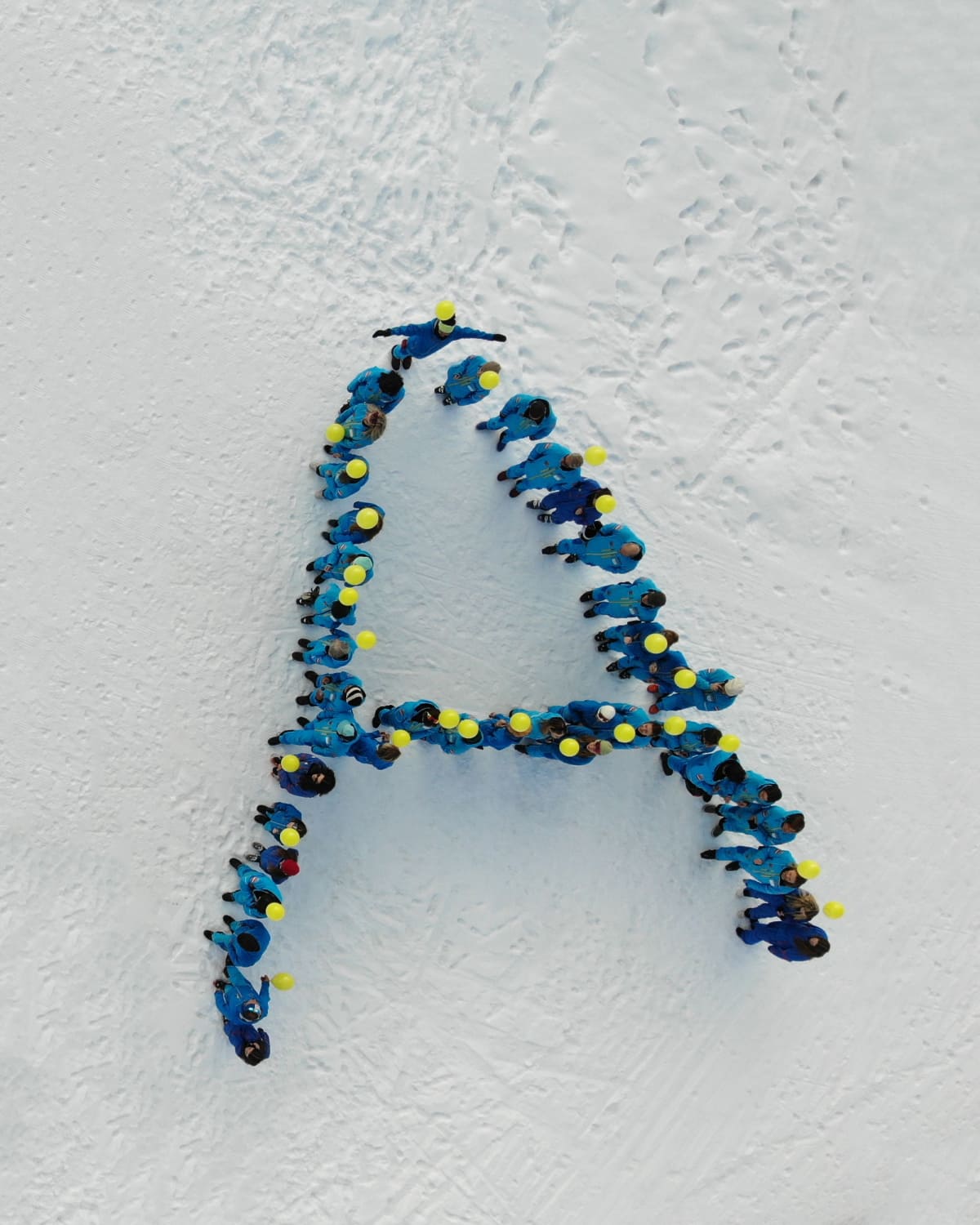 Skilehrer/Innen bilden den Buchstaben A